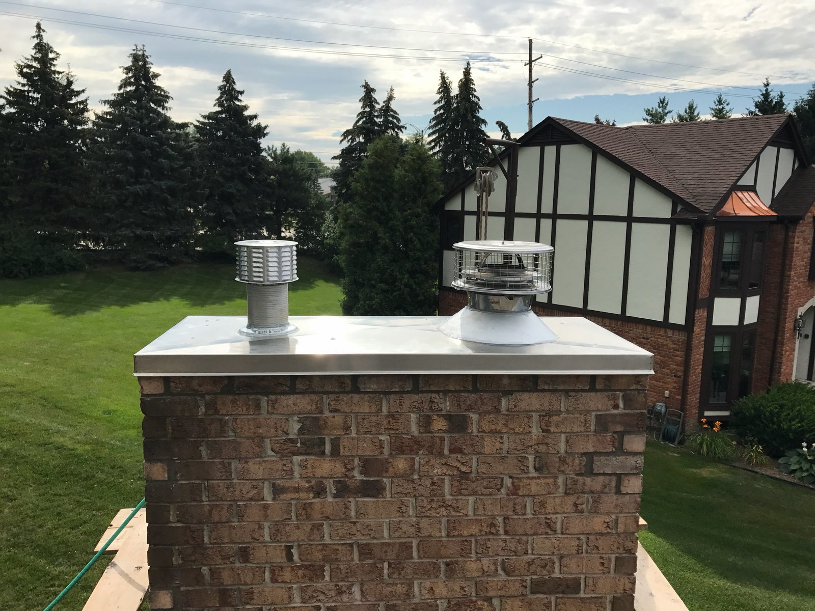 Stainless steel chase cover on brick chimney